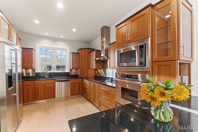 6 Brighton Way Unit 4D, Clayton, MO 63105 - kitchen with appliances with stainless steel finishes, brown cabinetry, wall chimney range hood, light wood-style flooring, and dark stone counters