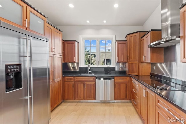 6 Brighton Way Unit 4D, Clayton, MO 63105 - kitchen featuring appliances with stainless steel finishes, wall chimney range hood, brown cabinets, recessed lighting, and glass insert cabinets