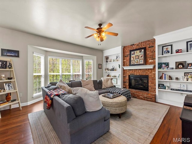 1509 Cedar Ridge Dr, Ofallon, IL 62269 - living room with ceiling fan, dark wood-type flooring, built in shelves, baseboards, and a fireplace