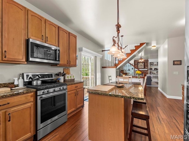 1509 Cedar Ridge Dr, Ofallon, IL 62269 - kitchen featuring stainless steel appliances, a center island, dark wood finished floors, and a breakfast bar