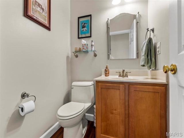 1509 Cedar Ridge Dr, Ofallon, IL 62269 - half bathroom featuring toilet, vanity, wood finished floors, and baseboards