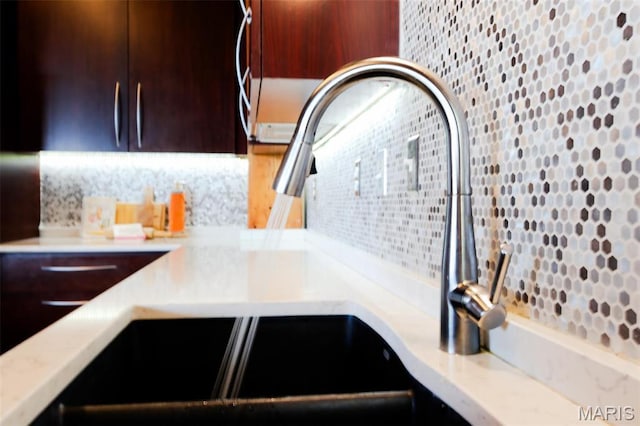 1015 Washington Ave Unit 507, Saint Louis, MO 63101 - kitchen view of backsplash, a sink, and dark brown cabinetry