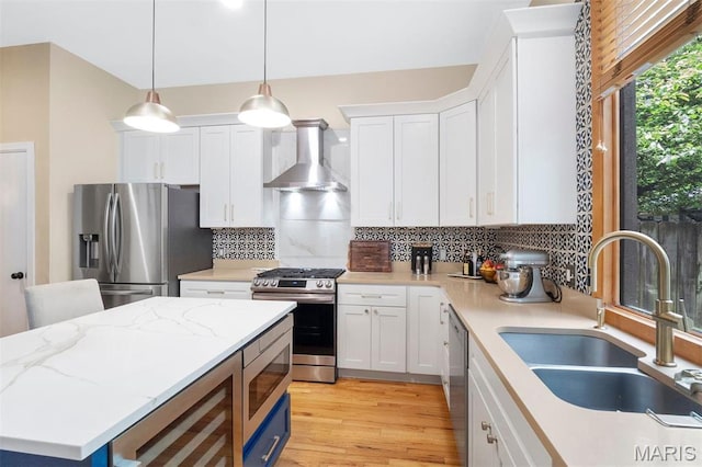 2209 Park Ave, Saint Louis, MO 63104 - kitchen featuring wall chimney exhaust hood, appliances with stainless steel finishes, a sink, wine cooler, and decorative backsplash