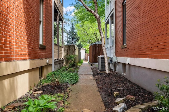 2209 Park Ave, Saint Louis, MO 63104 - view of property exterior with central AC, brick siding, and fence