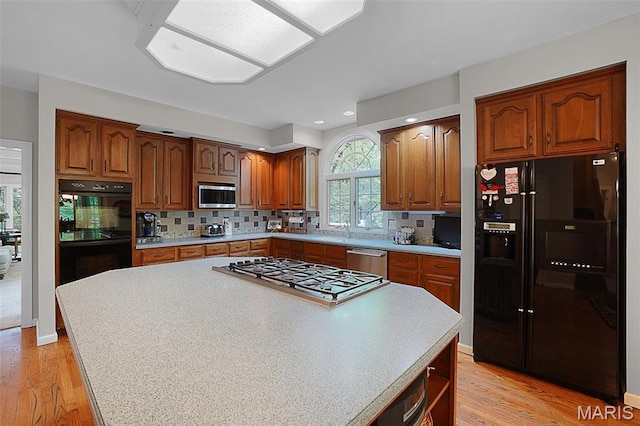 1508 Pacland Ridge Ct, Chesterfield, MO 63005 - kitchen featuring black appliances, light wood finished floors, light countertops, a center island, and recessed lighting