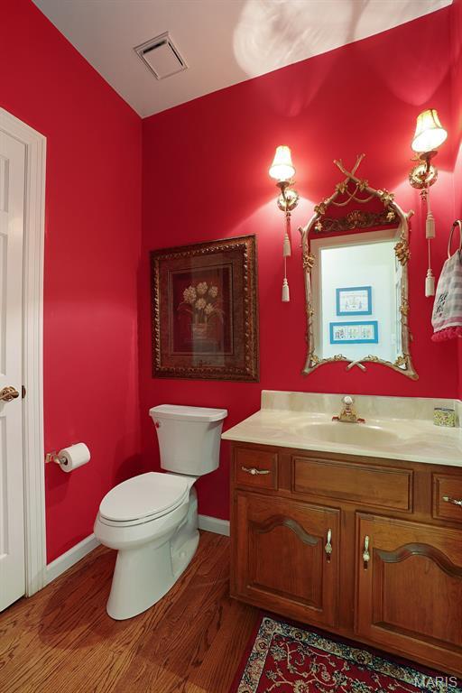1508 Pacland Ridge Ct, Chesterfield, MO 63005 - bathroom with toilet, vanity, wood finished floors, and baseboards