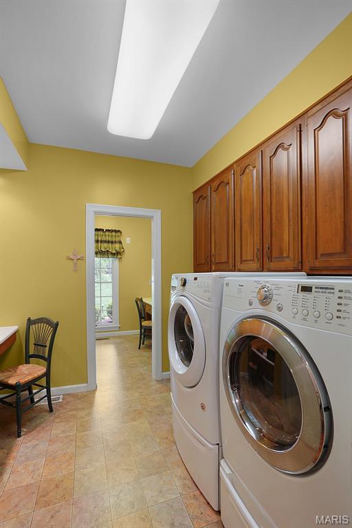 1508 Pacland Ridge Ct, Chesterfield, MO 63005 - laundry room featuring washer and dryer, cabinet space, and baseboards