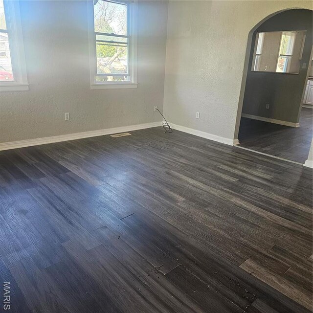 600 Plum, Cahokia, IL 62206 - spare room featuring arched walkways, baseboards, dark wood-style floors, and a textured wall