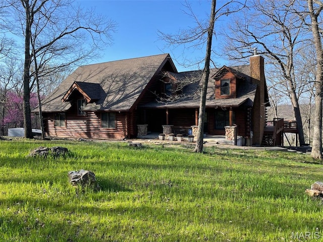 view of front of property with log siding and a chimney