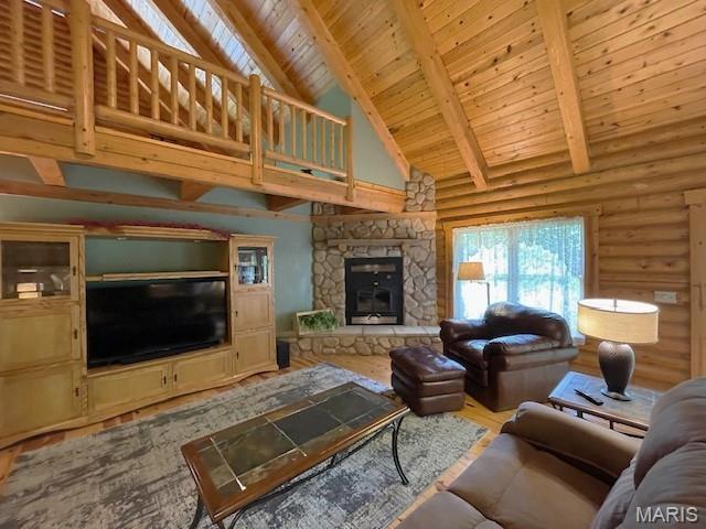 577 Schluersburg Rd, Augusta, MO 63332 - living area featuring a stone fireplace, wood ceiling with exposed beams, high vaulted ceiling, wood finished floors, and log walls