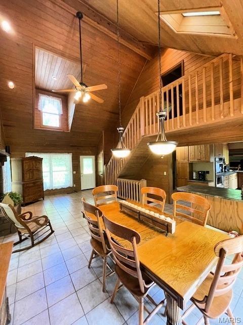 577 Schluersburg Rd, Augusta, MO 63332 - dining space with high vaulted ceiling, wood ceiling, a ceiling fan, light tile patterned floors, and wooden walls