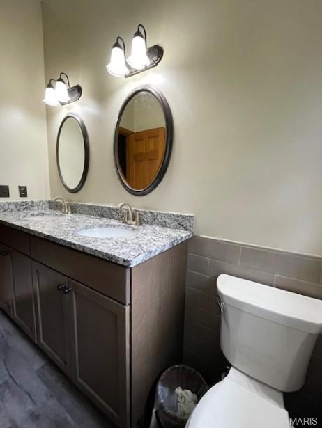 577 Schluersburg Rd, Augusta, MO 63332 - bathroom with double vanity, toilet, and a wainscoted wall