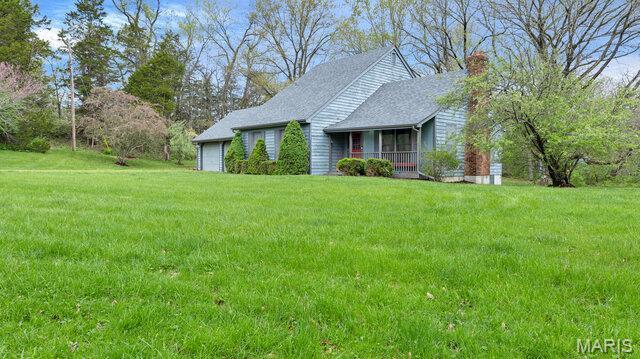 28470 Sunnyside Rd, Warrenton, MO 63383 - view of front of property with an attached garage, a front yard, and a chimney