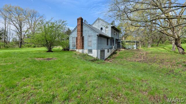 28470 Sunnyside Rd, Warrenton, MO 63383 - view of side of property with a chimney and a yard