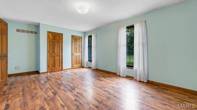 28470 Sunnyside Rd, Warrenton, MO 63383 - unfurnished bedroom with wood finished floors, a textured ceiling, and baseboards