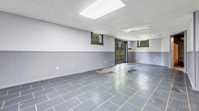 28470 Sunnyside Rd, Warrenton, MO 63383 - basement with a wainscoted wall, a drop ceiling, and dark tile patterned floors