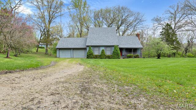 28470 Sunnyside Rd, Warrenton, MO 63383 - view of front facade featuring driveway, a front lawn, an attached garage, and a chimney