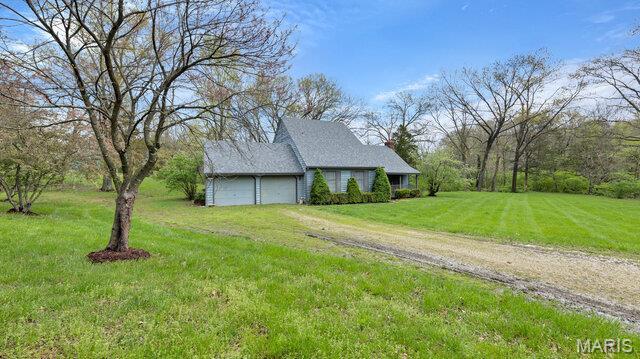 28470 Sunnyside Rd, Warrenton, MO 63383 - view of property exterior with driveway, a lawn, and a garage
