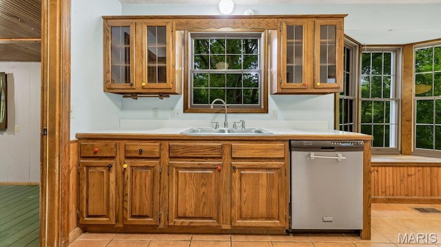 28470 Sunnyside Rd, Warrenton, MO 63383 - kitchen featuring stainless steel dishwasher, a sink, brown cabinetry, light countertops, and wooden walls