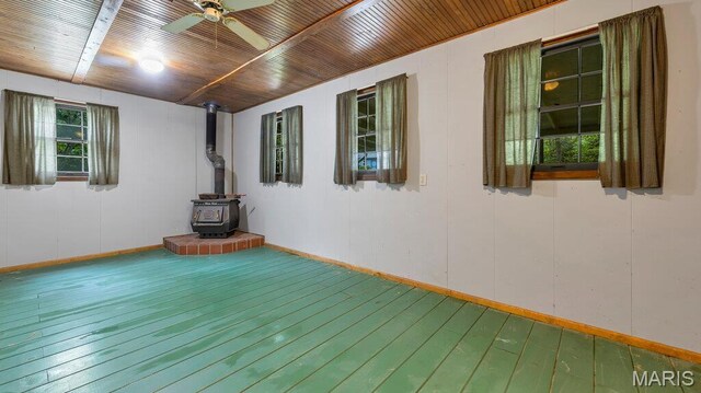 28470 Sunnyside Rd, Warrenton, MO 63383 - empty room with hardwood / wood-style floors, ceiling fan, a wood stove, and baseboards