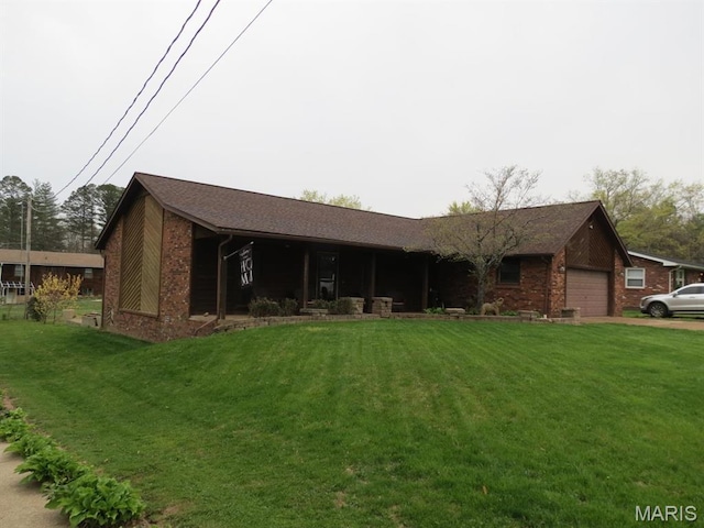 single story home with brick siding, a front yard, and a garage