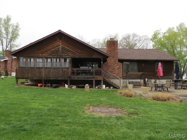 back of house with a patio, a yard, and a chimney