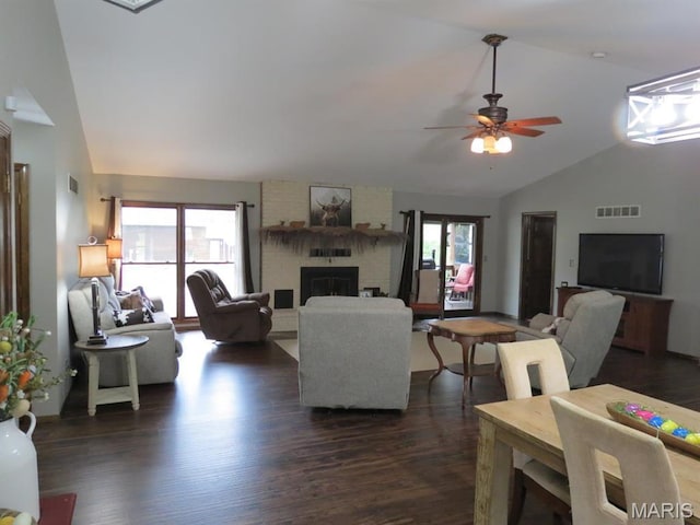 living room with dark wood finished floors, a fireplace, ceiling fan, and high vaulted ceiling