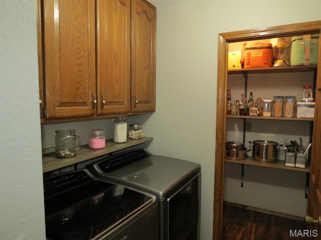 washroom with cabinet space, independent washer and dryer, and dark wood-style flooring