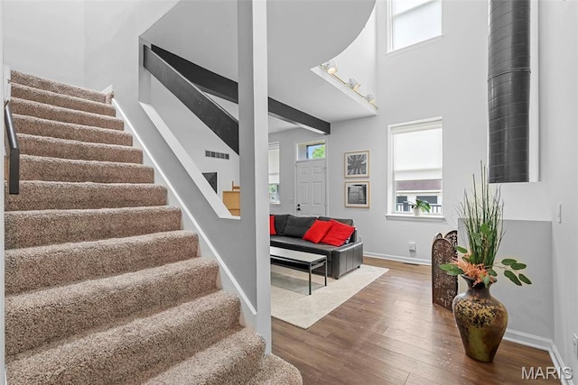 4366 W Pine Blvd Unit Cw, Saint Louis, MO 63108 - staircase with wood finished floors, baseboards, and a towering ceiling
