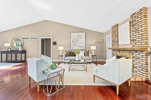 living area with wood-type flooring, vaulted ceiling, baseboards, and a fireplace