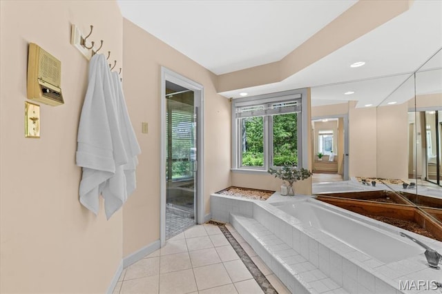 full bath featuring tile patterned floors, baseboards, a garden tub, and recessed lighting