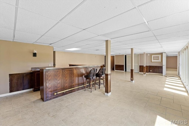 indoor bar with a drop ceiling and baseboards