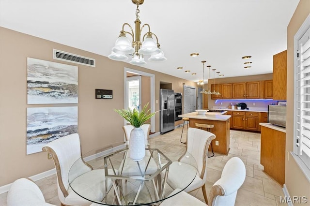dining area featuring a chandelier and baseboards