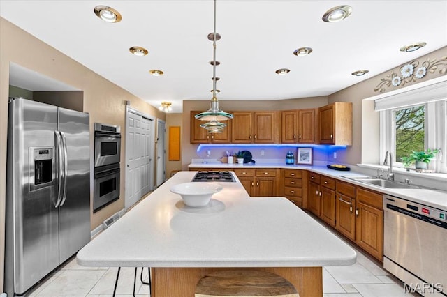 kitchen featuring appliances with stainless steel finishes, a sink, brown cabinetry, light countertops, and recessed lighting