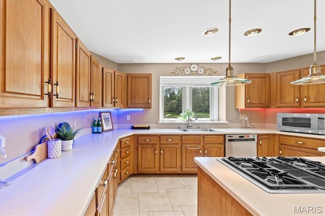 kitchen featuring appliances with stainless steel finishes, a sink, light countertops, decorative light fixtures, and recessed lighting