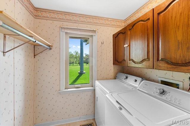 washroom with washer and dryer, cabinet space, wallpapered walls, and baseboards