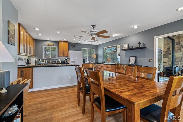 13219 Apache Point Dr, Saint Genevieve, MO 63670 - dining space featuring a wood stove, light wood-style floors, ceiling fan, and recessed lighting