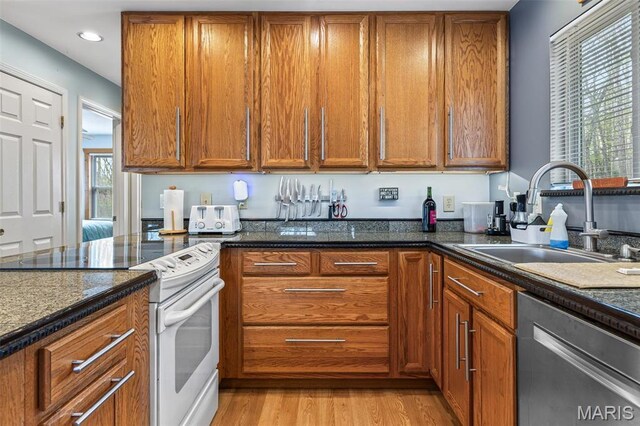 13219 Apache Point Dr, Saint Genevieve, MO 63670 - kitchen featuring white electric range oven, dishwasher, a sink, brown cabinetry, and recessed lighting