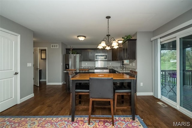 1338 Orchard Lakes Cir, Belleville, IL 62220 - dining room featuring a chandelier, dark wood finished floors, and baseboards