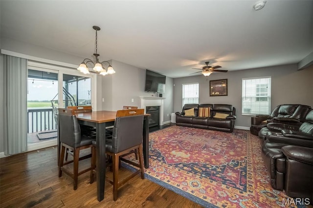 1338 Orchard Lakes Cir, Belleville, IL 62220 - dining room with ceiling fan, a chandelier, a fireplace, dark wood-style floors, and baseboards