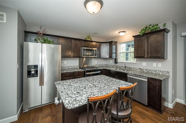 1338 Orchard Lakes Cir, Belleville, IL 62220 - kitchen featuring appliances with stainless steel finishes, dark brown cabinetry, a center island, and baseboards