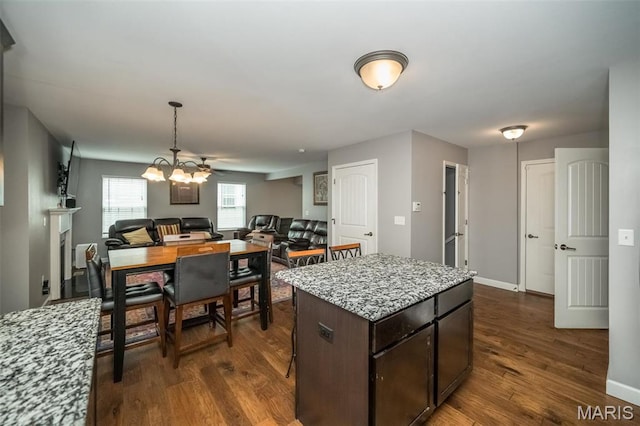 1338 Orchard Lakes Cir, Belleville, IL 62220 - kitchen featuring dark wood-style flooring, a center island, dark brown cabinets, open floor plan, and light stone counters