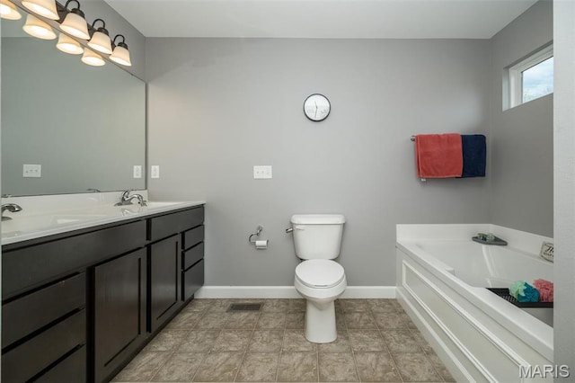 1338 Orchard Lakes Cir, Belleville, IL 62220 - bathroom featuring baseboards, toilet, a garden tub, and double vanity