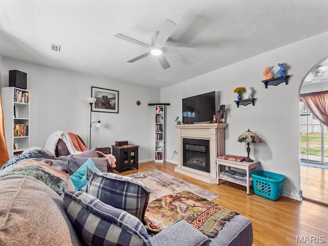 3701 Brandt Rd, Fults, IL 62298 - living room with a ceiling fan, a glass covered fireplace, wood finished floors, baseboards, and arched walkways