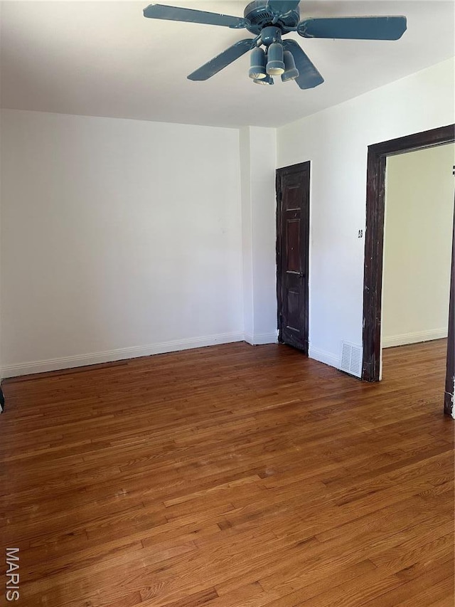 3460 Oakdale Ave, Saint Louis, MO 63121 - empty room with wood finished floors, a ceiling fan, and baseboards