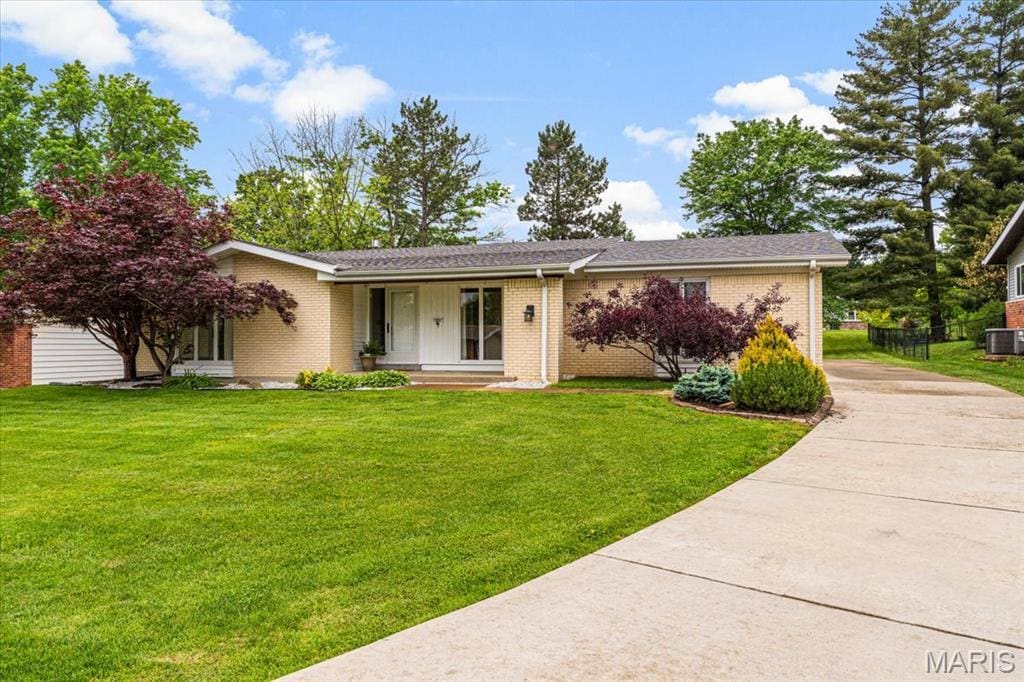 591 Fieldstone Ln, Ballwin, MO 63011 - view of front of house with concrete driveway, brick siding, a front lawn, and central air condition unit