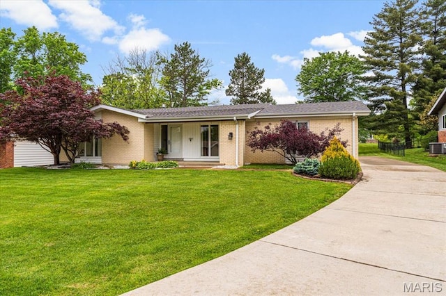 591 Fieldstone Ln, Ballwin, MO 63011 - view of front of house with concrete driveway, brick siding, a front lawn, and central air condition unit