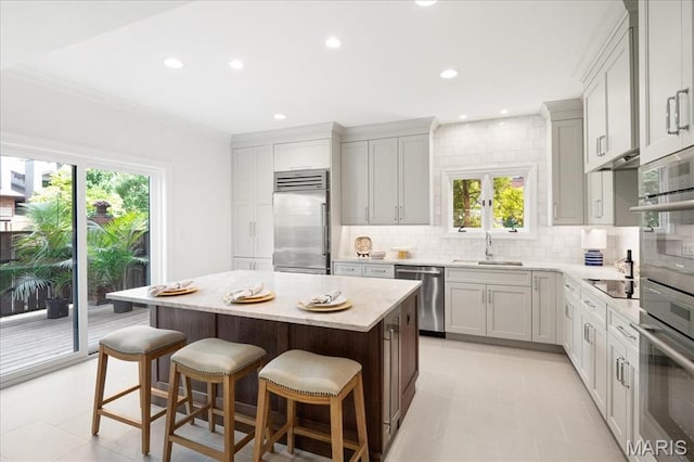 139 N Central Ave Unit P, Saint Louis, MO 63105 - kitchen with stainless steel appliances, decorative backsplash, a kitchen island, a kitchen bar, and healthy amount of natural light