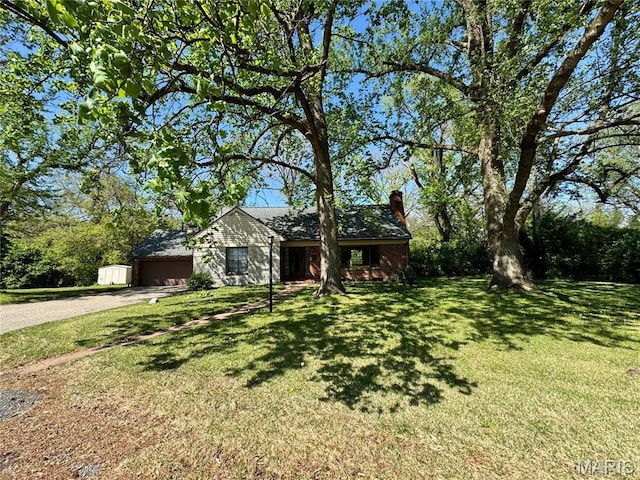 view of front of home featuring dirt driveway, a chimney, an attached garage, and a front lawn