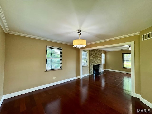unfurnished living room featuring ornamental molding, wood finished floors, a fireplace, and baseboards